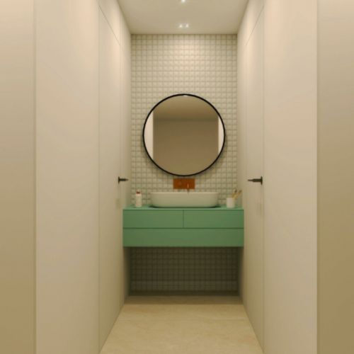 Baño con espejo circular y mueble en color verde agua