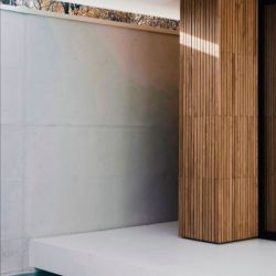 Columna exterior de vivienda junto a piscina revestida en madera